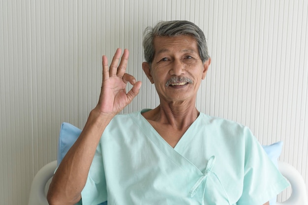 Retrato de un paciente mayor acostado en la cama en el concepto médico y de atención médica del hospital