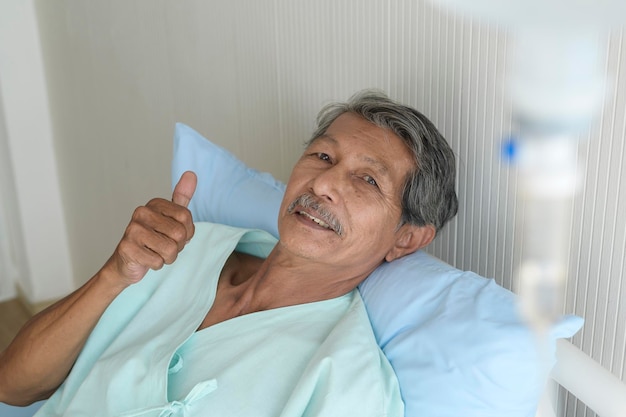 Retrato de un paciente mayor acostado en la cama en el concepto médico y de atención médica del hospital