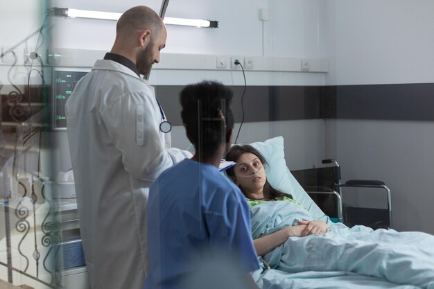 Foto retrato de un paciente mirando a un médico tendido en la cama