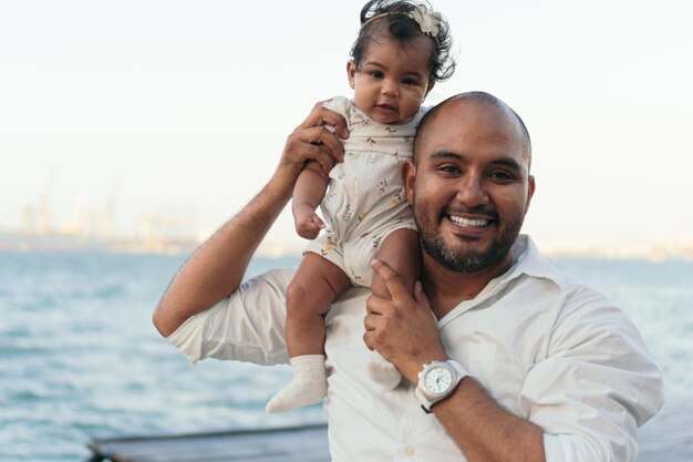 Retrato de un padre al aire libre mientras sostiene a su bebé y es cariñoso