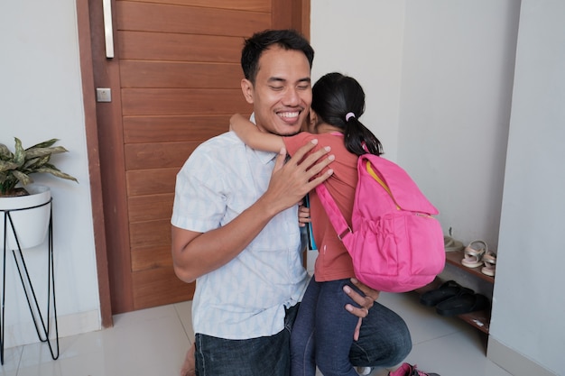 Retrato de padre asiático abraza a su hija antes de ir a la escuela por la mañana