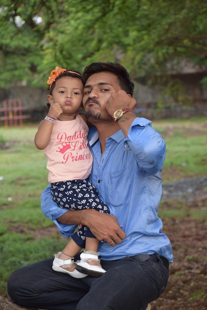 Foto retrato de padre e hija gestando en el parque