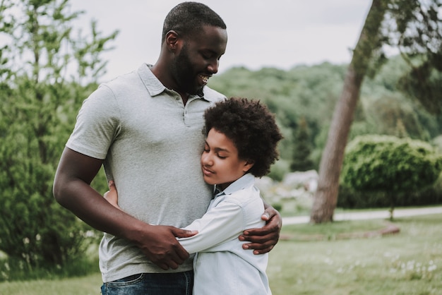 Retrato de padre e hijo se abrazan en la naturaleza.