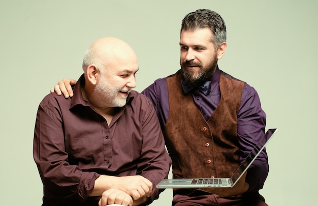 Retrato padre e hijo sosteniendo una computadora portátil dos socios comerciales que trabajan con una computadora portátil juntos t