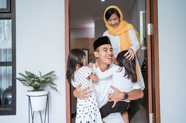 Retrato de padre emocionado abrazar y abrazar a sus hijos durante la celebración de eid mubarak juntos