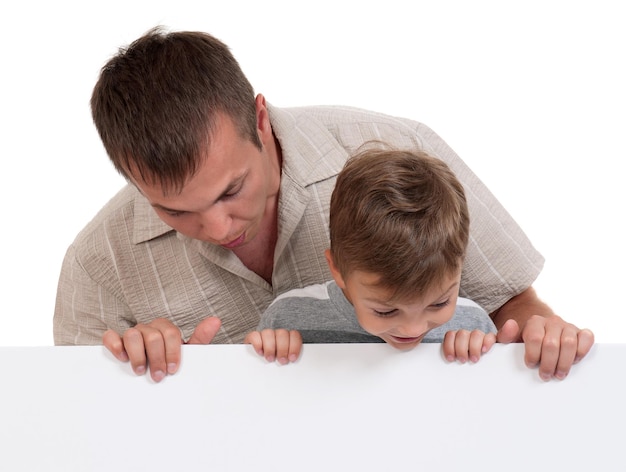 Retrato de padre y hijo felices con una tabla blanca vacía aislada sobre un fondo blanco