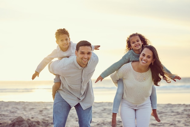 Retrato de padres a cuestas niños en la playa para vacaciones familiares vacaciones de verano y fin de semana Viajes por la naturaleza y feliz madre padre e hijos jugando junto al océano para divertirse y pasar un buen rato