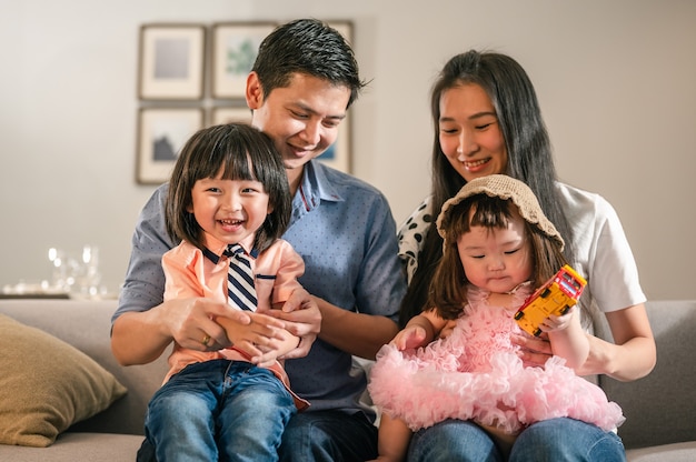 Retrato de padres feliz familia completa con niños divertirse sentados en el sofá en el ocio de la sala de estar