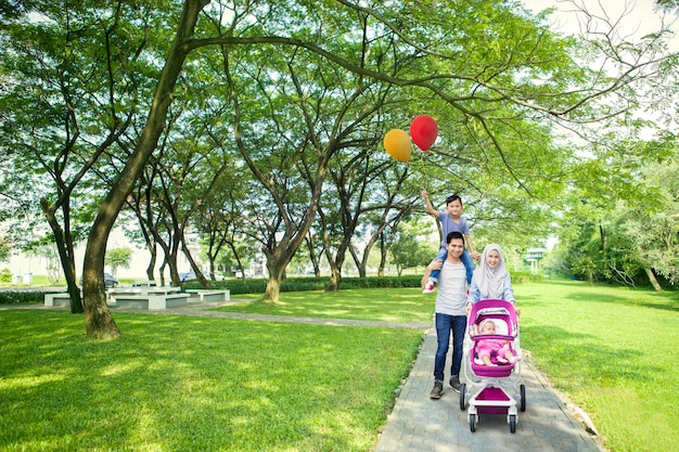 Retrato de padres sonrientes con hijos en el parque