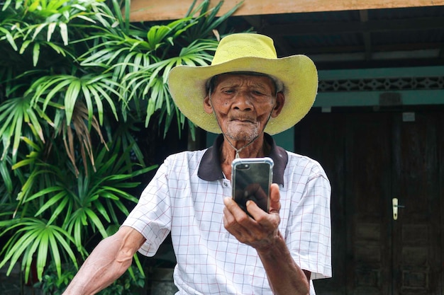 Un retrato de la pantalla de reloj del abuelo indonesio en el teléfono inteligente