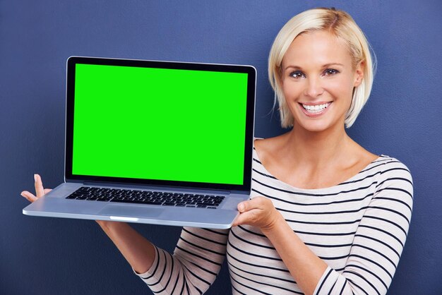 Retrato de pantalla verde y mujer con una conexión portátil e internet en un fondo de estudio azul Cara de persona y espacio de maqueta con modelo y computadora con correo electrónico y promoción con tecnología