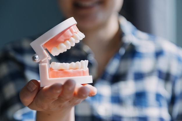 Foto retrato parcial do conceito de estomatologia de menina com dentes brancos fortes olhando para a câmera e dedos sorridentes perto do rosto closeup de jovem no estúdio do dentista dentro de casa