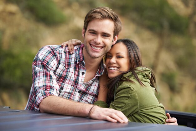 Foto retrato de pareja abrazada y viaje por carretera para viajar feliz con el amor y la aventura en australia vacaciones de libertad y personas al aire libre con confianza y compromiso viaje y sonrisa para viajar a través del país