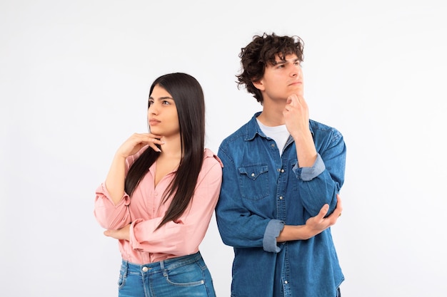 Foto retrato de una pareja de adolescentes hispanos pensativos pensando en fondo blanco