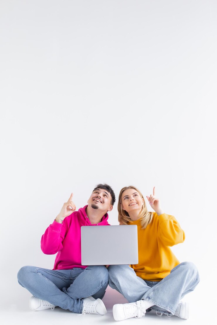 Retrato de una pareja alegre emocionada sosteniendo una computadora portátil
