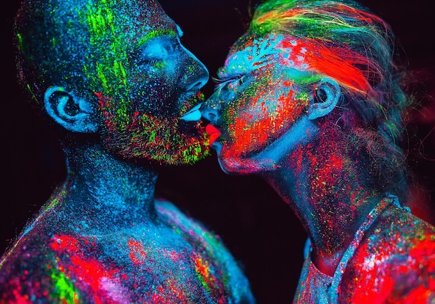 Retrato de una pareja de amantes pintados en polvo fluorescente.