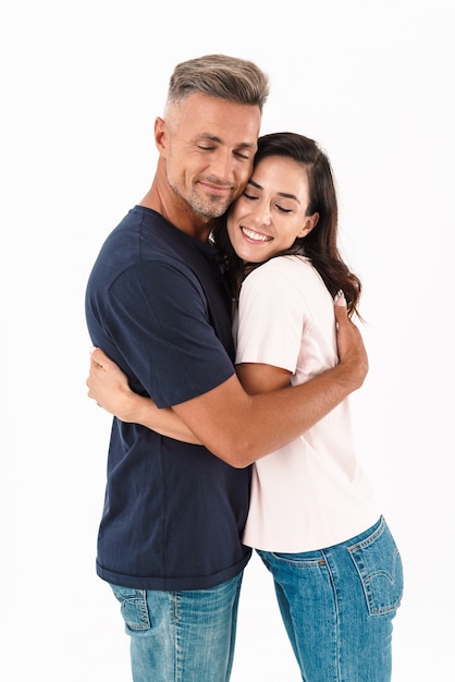 Retrato de una pareja amorosa adulta feliz alegre aislada sobre la pared blanca.