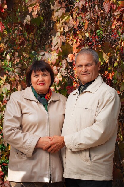 Retrato de una pareja de ancianos en el bosque de otoño del parque