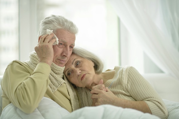 Retrato de pareja de ancianos enfermos en la cama