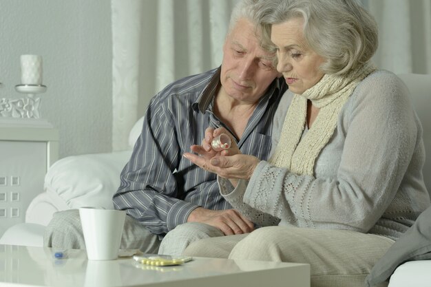 Retrato de pareja de ancianos enfermos con pastillas