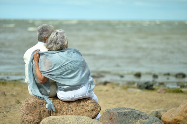 Retrato de una pareja de ancianos en el mar al atardecer