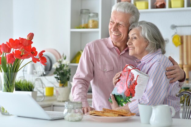 Retrato de una pareja de ancianos con un portátil