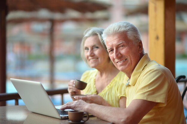 Retrato de una pareja de ancianos con un portátil