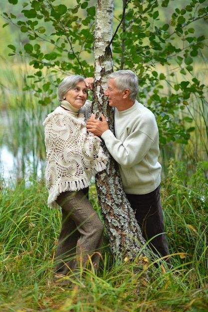 Retrato de pareja de ancianos posando en el bosque de otoño