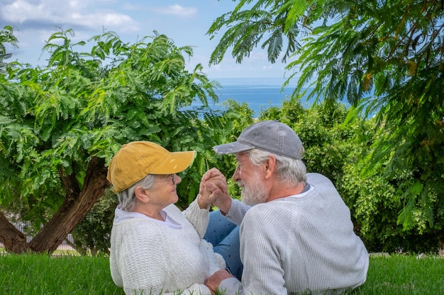 Retrato de una pareja de ancianos sonrientes tumbados en el césped en un parque público mirándose a los ojos Encantadora pareja de ancianos disfrutando del tiempo libre y la jubilación