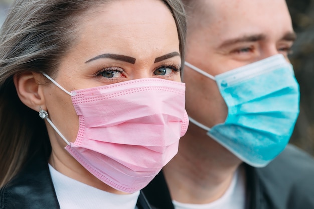 Retrato de una pareja de aspecto europeo con máscaras médicas.