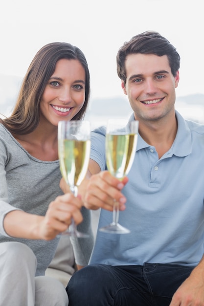 Retrato de una pareja brindando sus flautas de champán