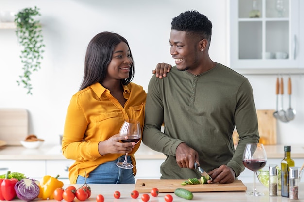 Retrato de una pareja casada negra positiva que se relaja en la cocina juntos