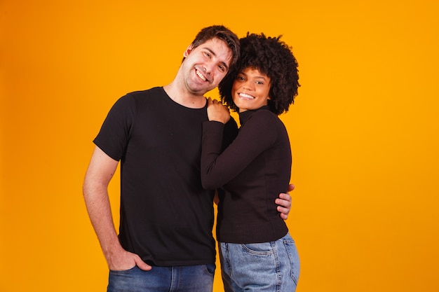 Retrato de pareja de contenido en ropa básica sonriendo a la cámara