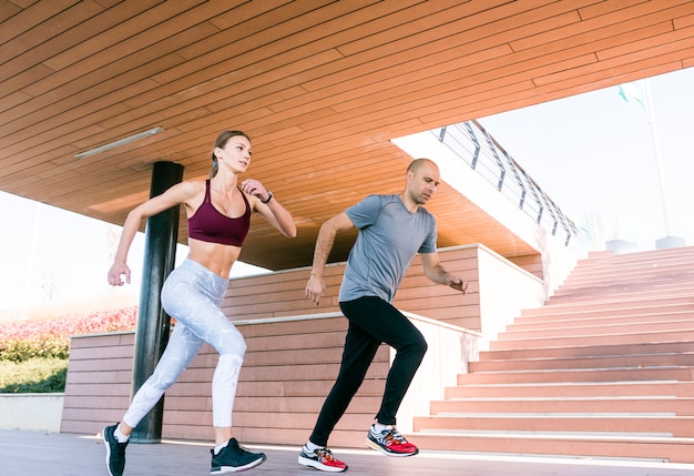 Retrato de pareja corriendo y corriendo al aire libre