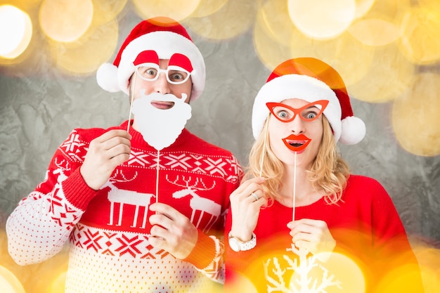 Retrato de pareja divertida con accesorios de papel de Navidad. Hombre y mujer divirtiéndose juntos