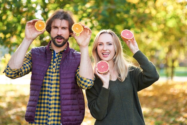 Retrato de pareja divirtiéndose con frutas