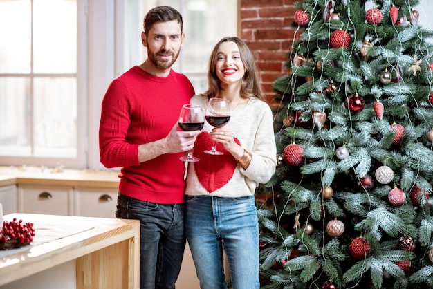 Retrato de una pareja encantadora cerca del árbol de navidad en casa