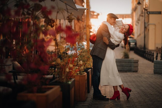 Retrato de una pareja feliz abrazándose en la calle en una ciudad de otoño Pareja con estilo retro en otoño en la ciudad