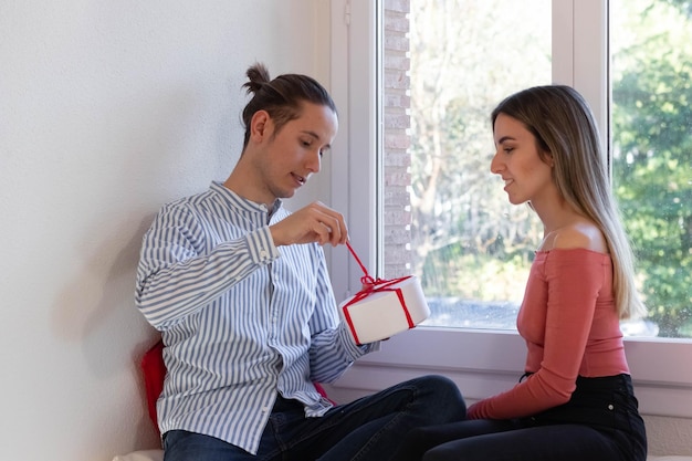 Retrato de una pareja feliz y emocionada abriendo un regalo