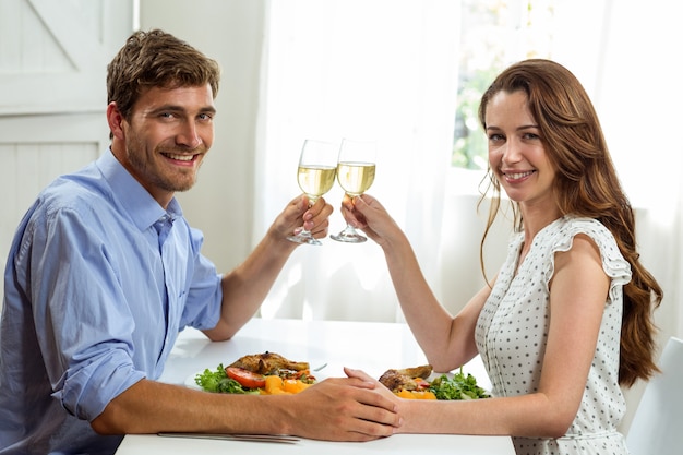 Retrato de una pareja feliz tostado copas mientras almorzaba