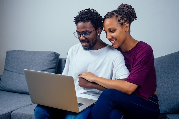 Retrato de una pareja feliz usando una computadora portátil en su casa