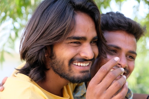 Retrato de una pareja gay india emocionada abrazándose y sonriendo en un parque