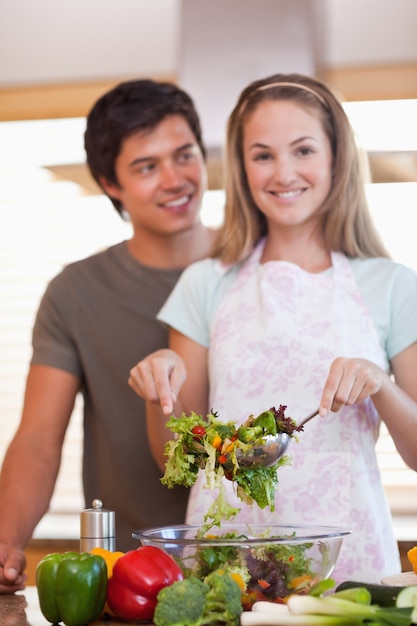 Foto retrato de una pareja haciendo una ensalada