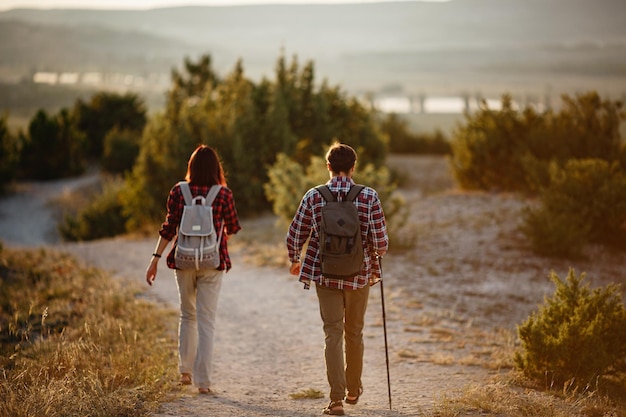 Retrato de una pareja joven feliz divirtiéndose en su viaje de senderismo Pareja de excursionistas caucásicos y asiáticos divirtiéndose en las vacaciones de verano