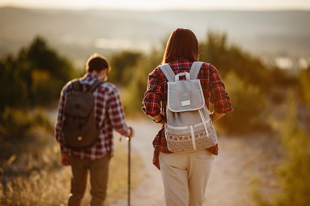 Retrato de una pareja joven feliz divirtiéndose en su viaje de senderismo Pareja de excursionistas caucásicos y asiáticos divirtiéndose en las vacaciones de verano