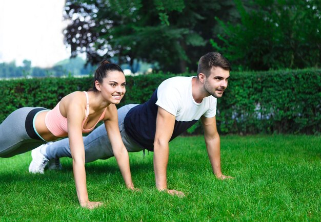 Foto retrato de una pareja joven sentada en la hierba