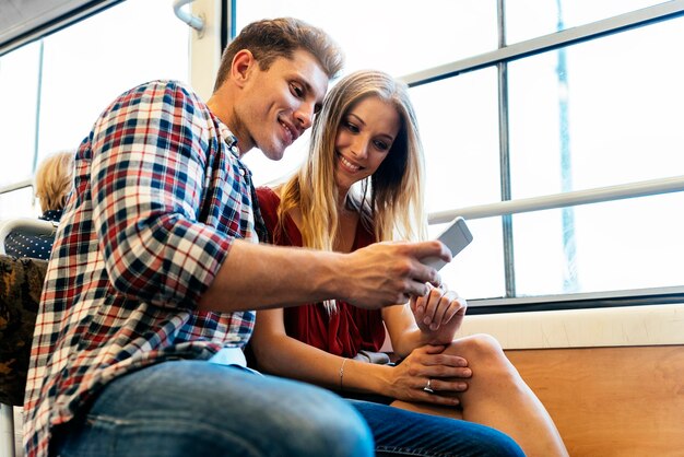 Foto retrato de pareja joven mediante teléfono móvil en la calle. concepto móvil.