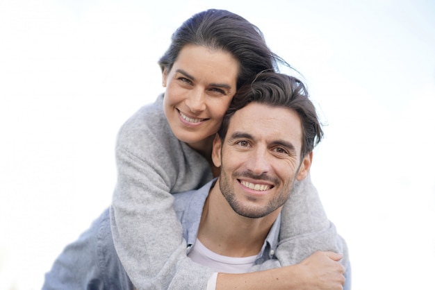 Retrato de pareja magnífica al aire libre piggybacking