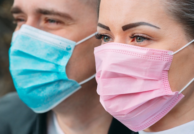 Retrato de una pareja con máscaras médicas.