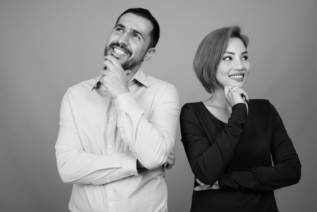 Retrato de pareja multiétnica juntos y enamorados en gris en blanco y negro